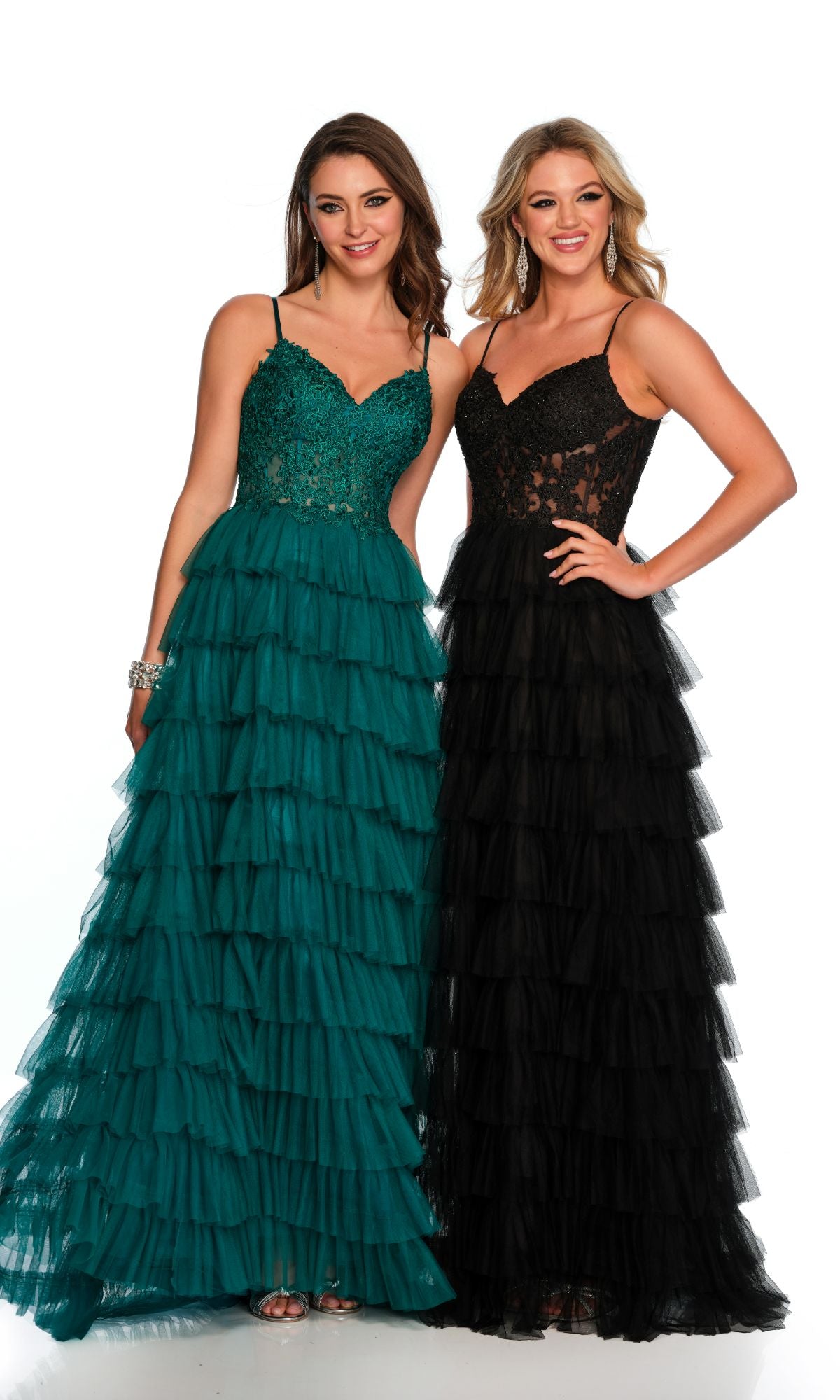 Two women stand in Dave and Johnny Long Tiered Prom Dress 11148: one wears teal with a lace bodice, the other black with a matching lace v-neck. Both showcase elegant, long tiered prom dresses with flowing tulle layers.